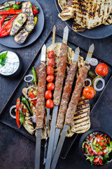 Traditioneller türkischer Adana Kebap am Schaschlik Spieß mit Grillgemüse und Fladenbrot...
