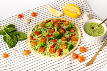 vegan pizza, with broccoli and spinach on a white table