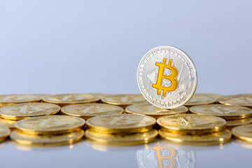 Golden bitcoin coin standing on top of other coins