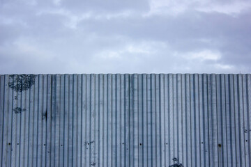 Fototapeta premium Metal fence close-up. Corrugated metal fence. Decking metal fence.