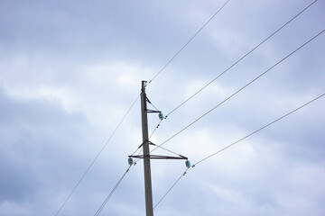 Power lines against the sky. Wires on electric poles against the gray sky. High voltage wires electricity.