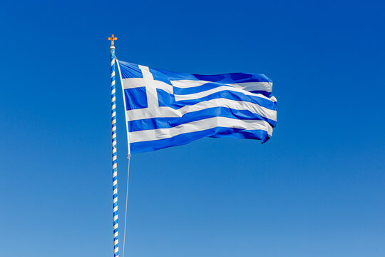 Greek flag waving against the blue sky. - Powered by Adobe