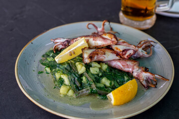Grilled baby squids with spinach, potato and lemon