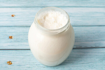 milk cream in a glass jar on a blue table