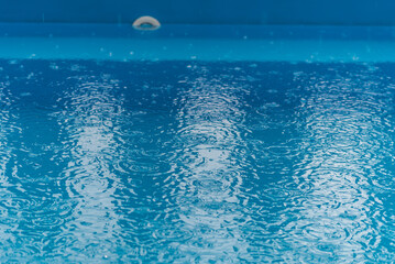 Fototapeta na wymiar rain drops falling in the pool