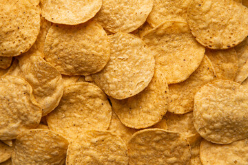 A closeup image of freshly baked and salted yellow corn tortilla chips.