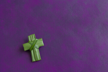 Isolated palm cross on a dark purple background with copy space