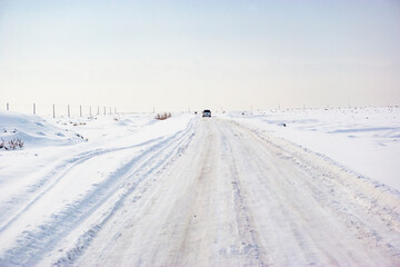 Car driving on a snowy road, Aksu Prefecture, Xinjiang, China