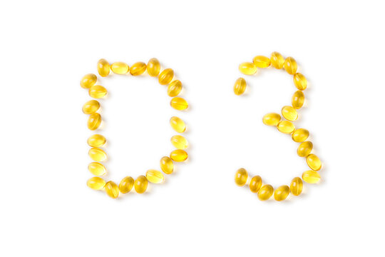 Yellow oil capsules with vitamin D poured from a plastic white bottle and forming shape D3 on the white background. - Image