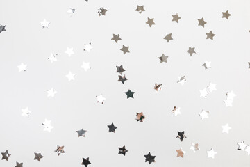 Fototapeta na wymiar star silver confetti on white background flat lay text place .