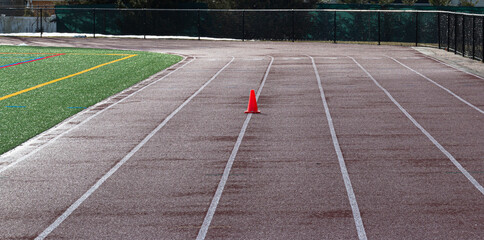 One orange cone on a wet track