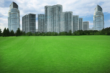 Fototapeta na wymiar Beautiful view of park with green lawn and cityscape on sunny day