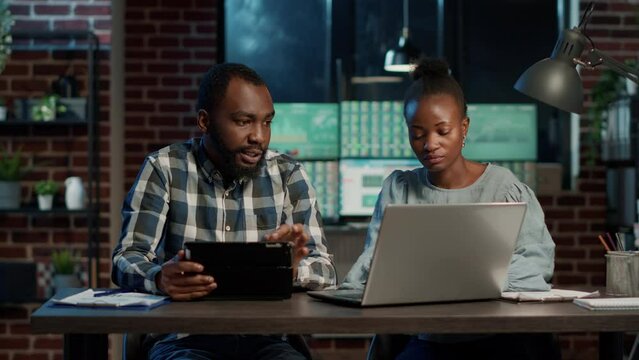 Man and woman brainstorming financial ideas to plan forex sales growth with laptop and digital tablet. Teamwork to develop business profit with stock market exchange, money trade.