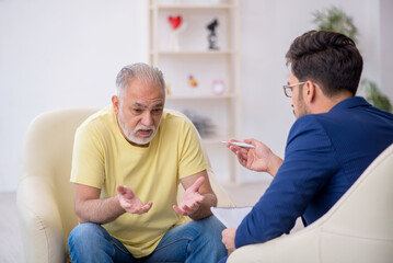 Old man visiting young male psychotherapist