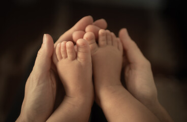 close up of mother holding tinny baby's feet, childcare and new life concept 