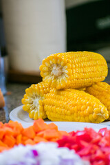Fresh boiled cob corn on a White plate.