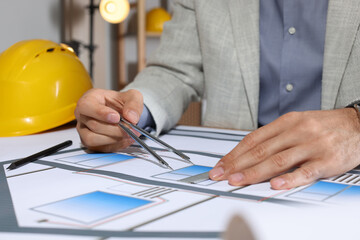 Architect working with construction drawings in office, closeup