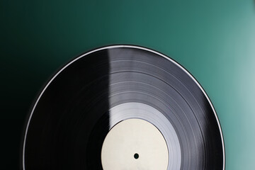 Classic vinyl record close-up on a green background, obsolete data storage, music