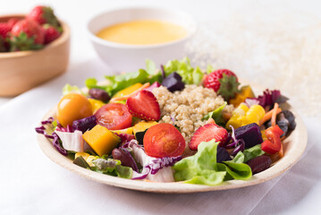 Fresh mixed fruits and vegetables salad in natural plate on white background, Healthy vegan food