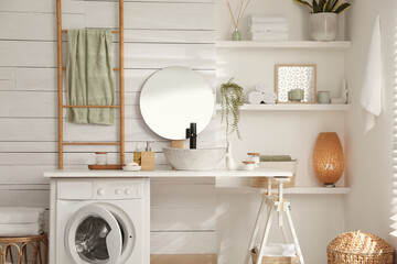 Stylish bathroom interior with modern washing machine
