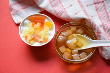 Chinese desserts, milk pudding fruit salad and Mix ginkgo nuts cassava syrup coconut jelly in longan juice on glass bowl, Thai and Chinese longan date soup Asian dessert sweets