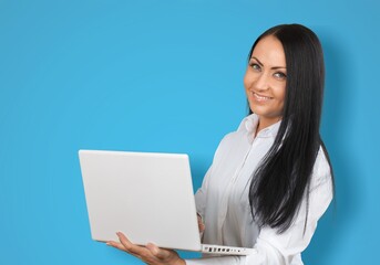 Portrait of attractive cheerful skilled girl using laptop on a background