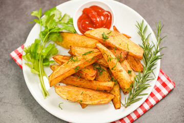 Potato wedges on white plate with rosemary herb coriander and tomato ketchup sauce, Cooking french fries or fry potatoes
