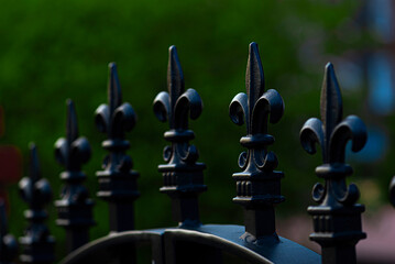 Closeup of a wrought iron fence on warm dark background
