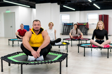 Women's and men's group on a sports trampoline, fitness training, healthy life - a concept trampoline group batut instructor men, for fit team in training from exercise person, wellness sportswear