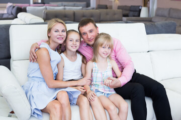 Parents with kids is pleased by new sofa in furniture store