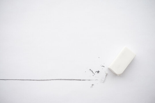 Flat lay of white eraser delete black line pencil on white paper background copy space. Repair, remove, creative idea, imagination and education concept.