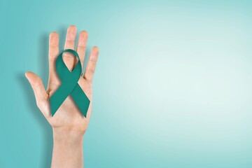 Teal awareness ribbon awareness for Ovarian Cancer month, hand with ribbon