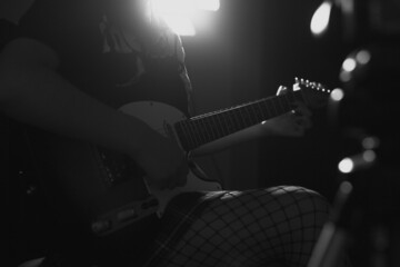 Silueta de joven mujer tocando una guitarra electrica