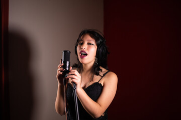 Mujer joven cantando emocionada en un estudio
