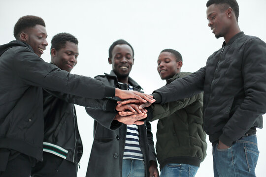 close up. group of guys putting their hands together.