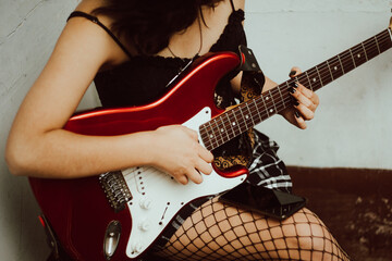 Joven mujer tocando la guitarra eléctrica 