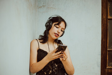 Mujer joven escuchando música con su teléfono móvil