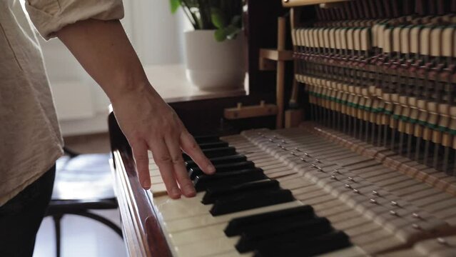 Woman touch keyboard of vintage wooden piano