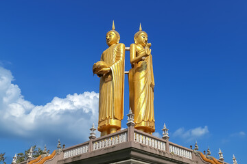 Fototapeta premium Standing Buddha statue against blue sky