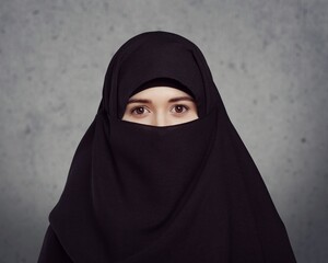 Portrait of young woman in black burqa with hidden face,