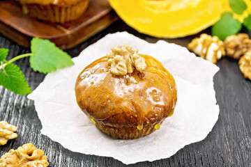 Cupcake pumpkin with orange glaze and walnuts on board