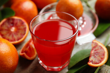 Tasty sicilian orange juice in glass and fruits on table, closeup