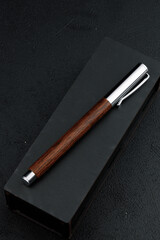 A set of expensive military pens in wooden boxes, compositions on a dark background with attributes. Luxury gift pen.