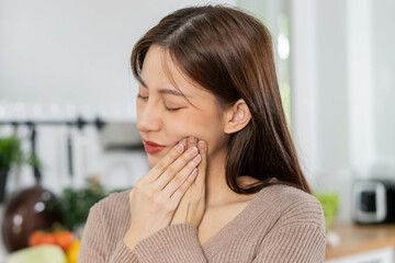 Closing eyes asian young woman touching cheek, face expression from toothache, tooth decay or sensitivity, Having tooth or teeth problem or inflammation, suffering from health. Sensitive teeth people