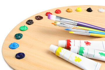 Palette with acrylic paints and brushes on white background, closeup. Artist equipment