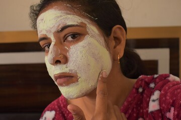 Indian Woman applying Neem face mask for pimple free skin