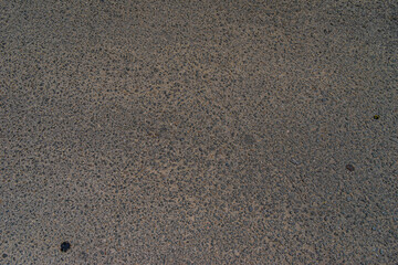 Fototapeta na wymiar Smooth concrete real road with cracks and clutch track. Great for travel and urban purposes. Rough road texture background. Rough cracked asphalt, small gravel road