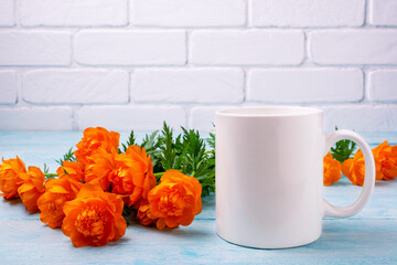 White coffee mug mockup with orange globeflowers