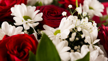 Closeup bouquet of red roses with with daisies.
