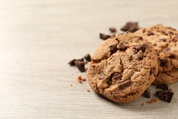 Delicious chocolate chip cookies on wooden table, closeup. Space for text